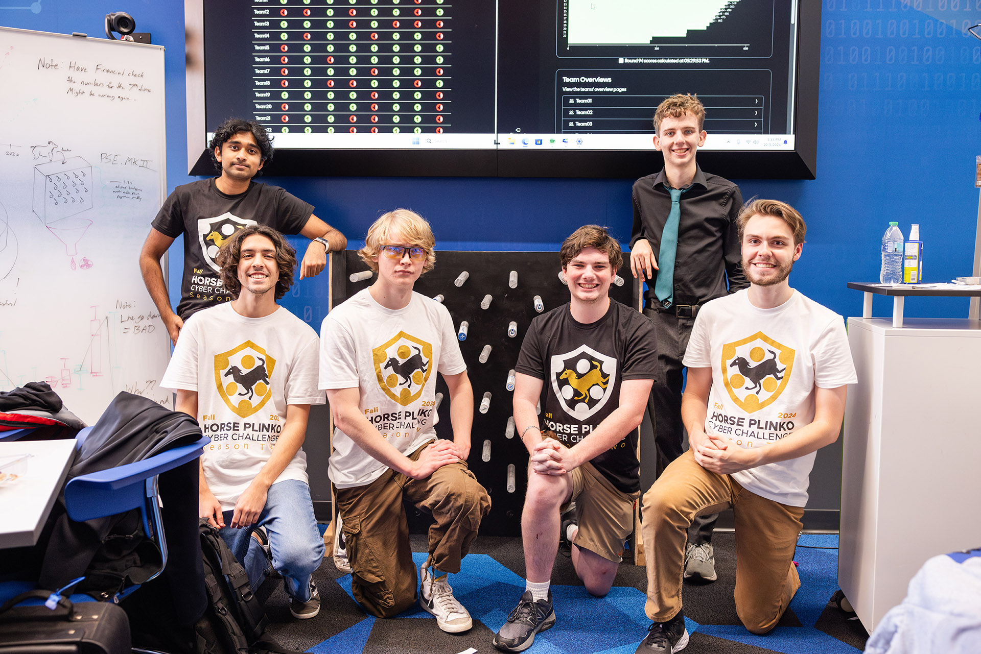 group of students in front of a plinko board