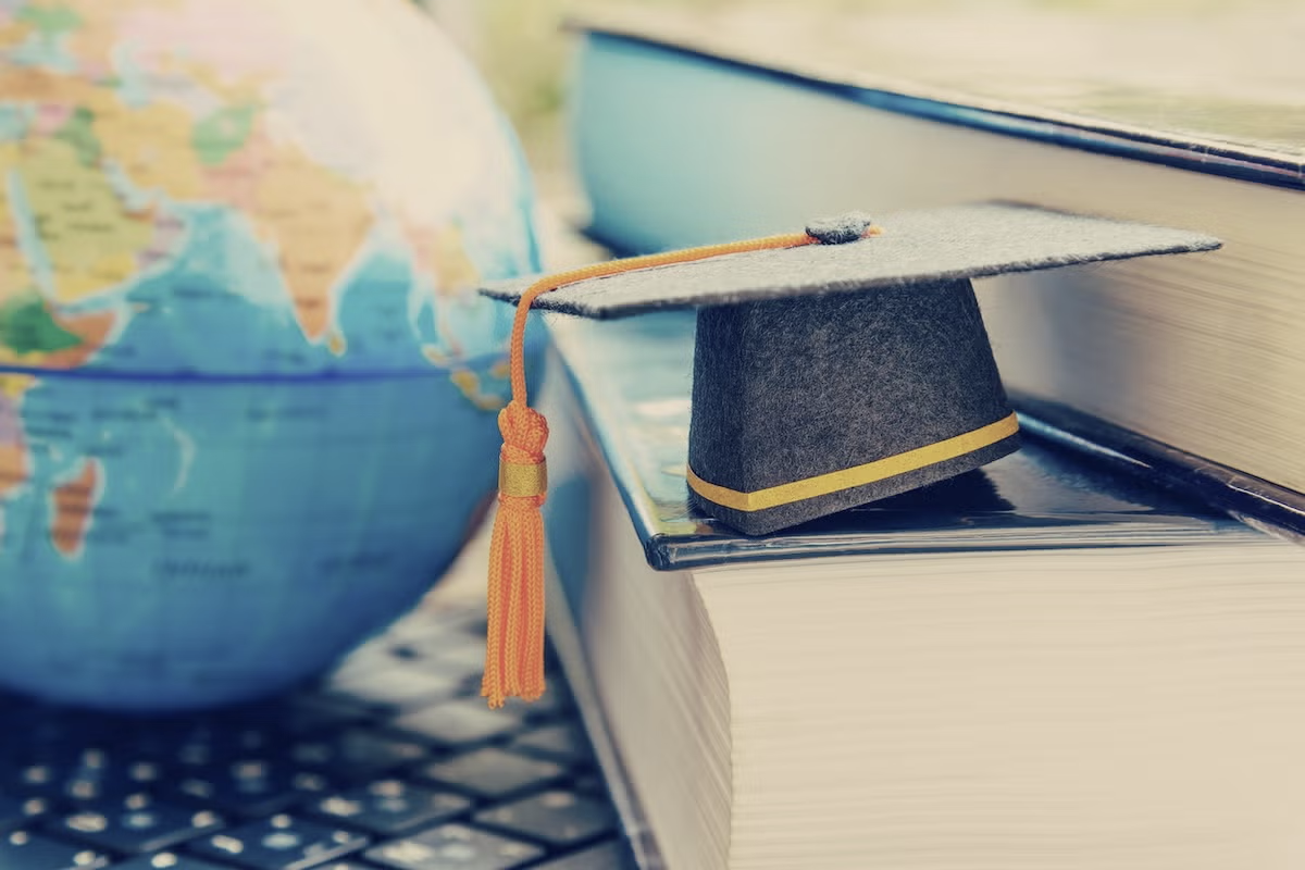 decorative image of globe, books and grad cap